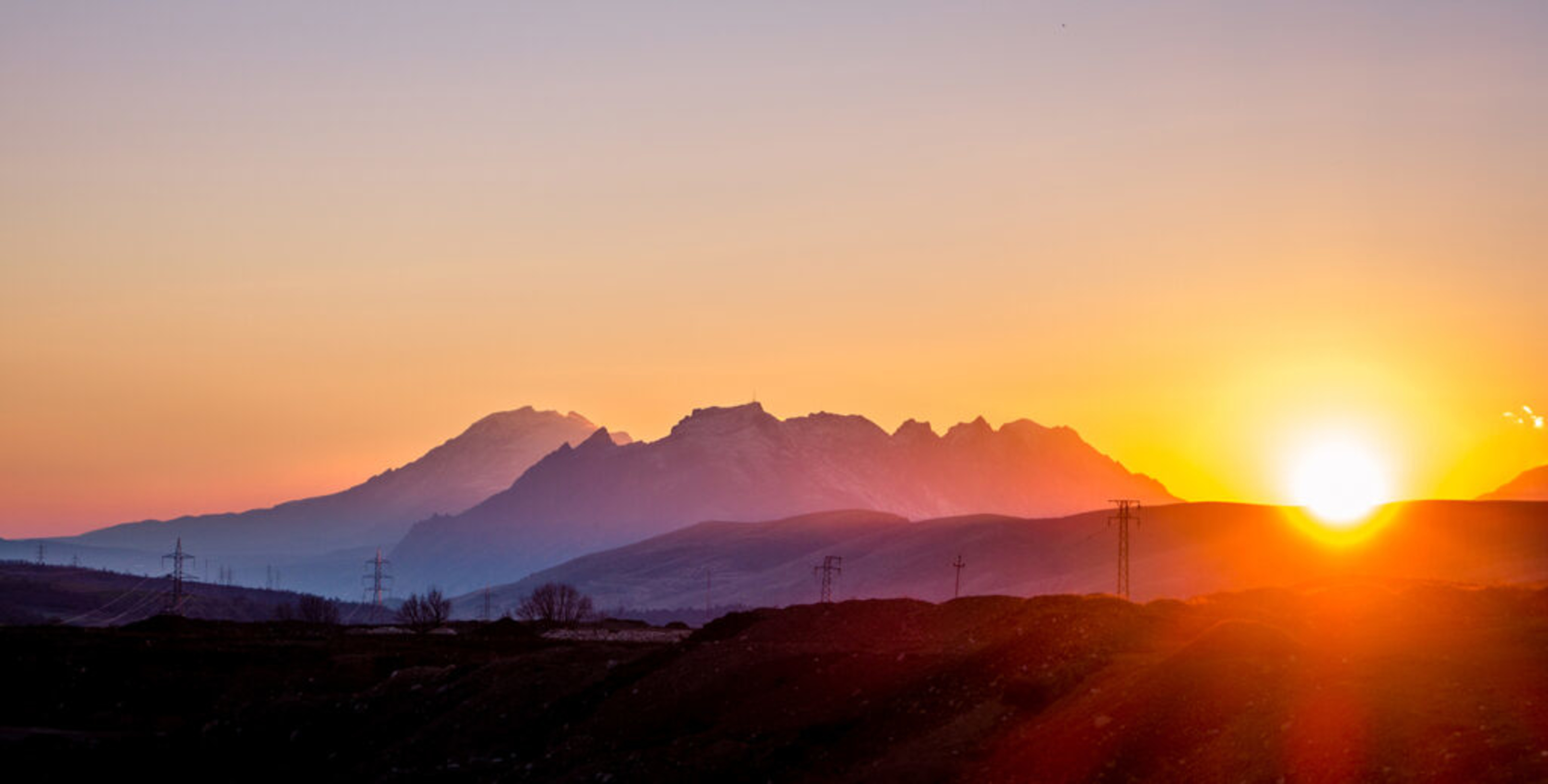 Sunset over mountain range, symbolizing a patience-filled approach of implementing an optimistic UI in software development.
