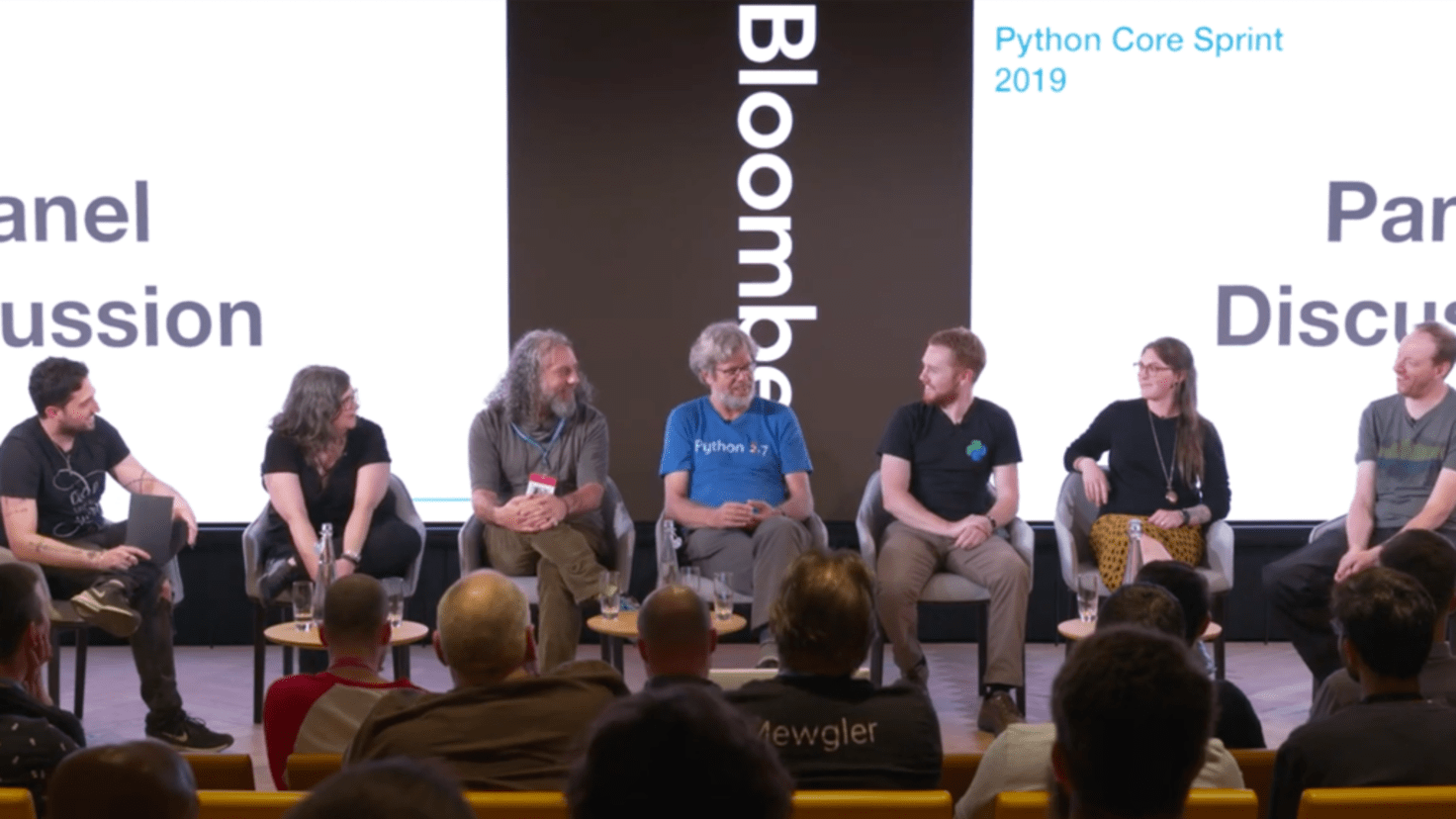 A panel of Python core developers engaging in a Q&A session at Bloomberg's London office, symbolizing collaboration and innovation in the Python community.