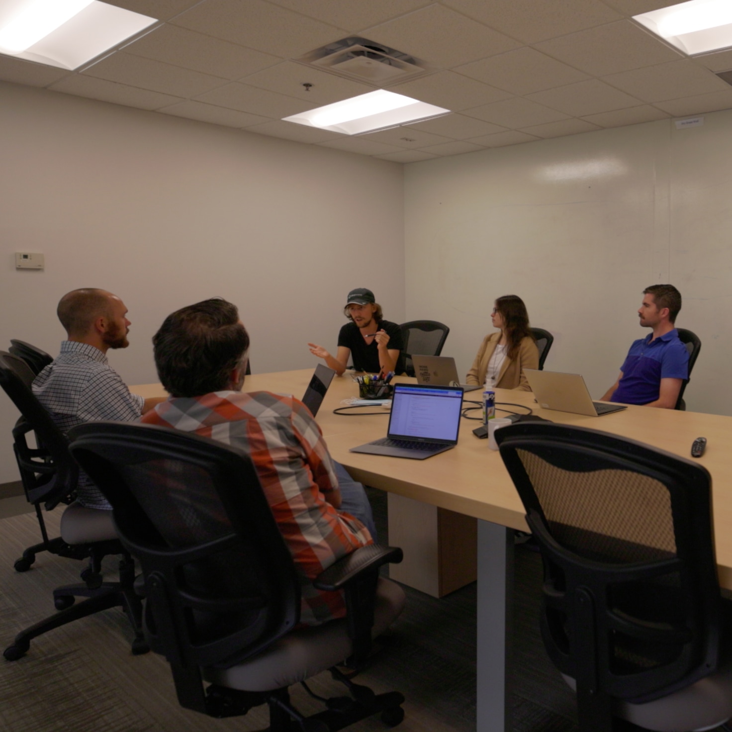 Emily and Scott sit with the team of developers and researchers at Dropworks.