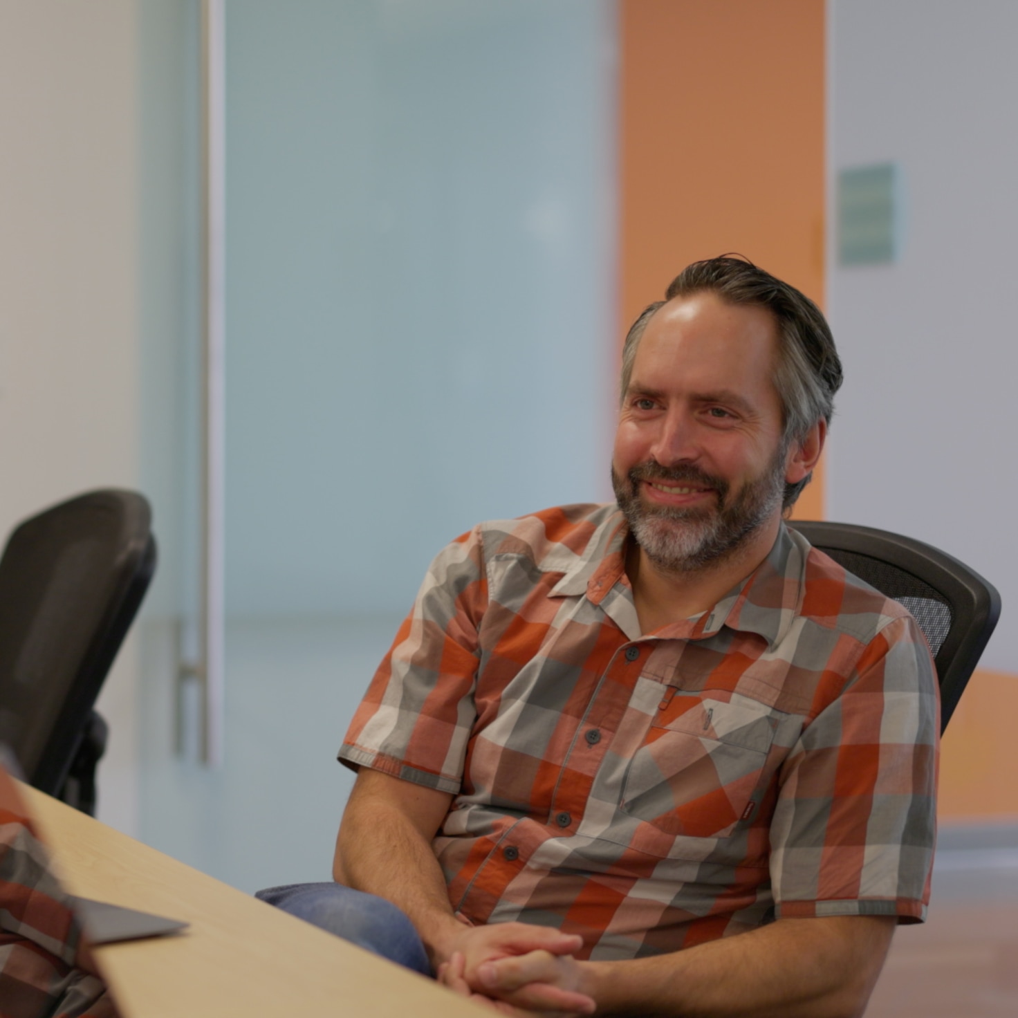 Scott smiles during a meeting at a client in the life sciences industry as the team designs a system to update remote equipment using GCP and Firestore.