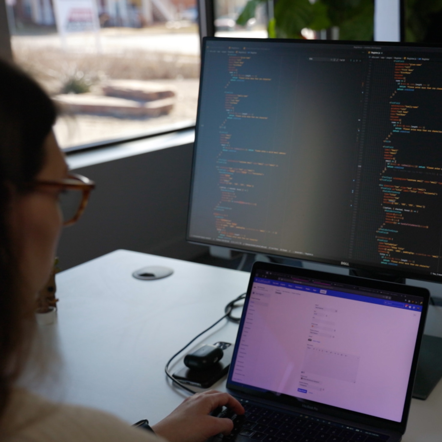 Emily, Cuttlesoft's lead finance software developer, immersed in coding a trading platform for real estate investors. She's working at a standing desk with three large monitors: one displays intricate Python code with Django framework structures, another shows real-time market data streams, and the third runs our Jira project management. On her desk, a notebook is open to a page filled with handwritten pseudocode and mathematical formulas. A whiteboard nearby is covered with flowcharts detailing the algorithm's decision tree. Emily is wearing noise-cancelling headphones, her focused expression illuminated by the screens' glow showcases Cuttlesoft's commitment to cutting-edge fintech solutions.